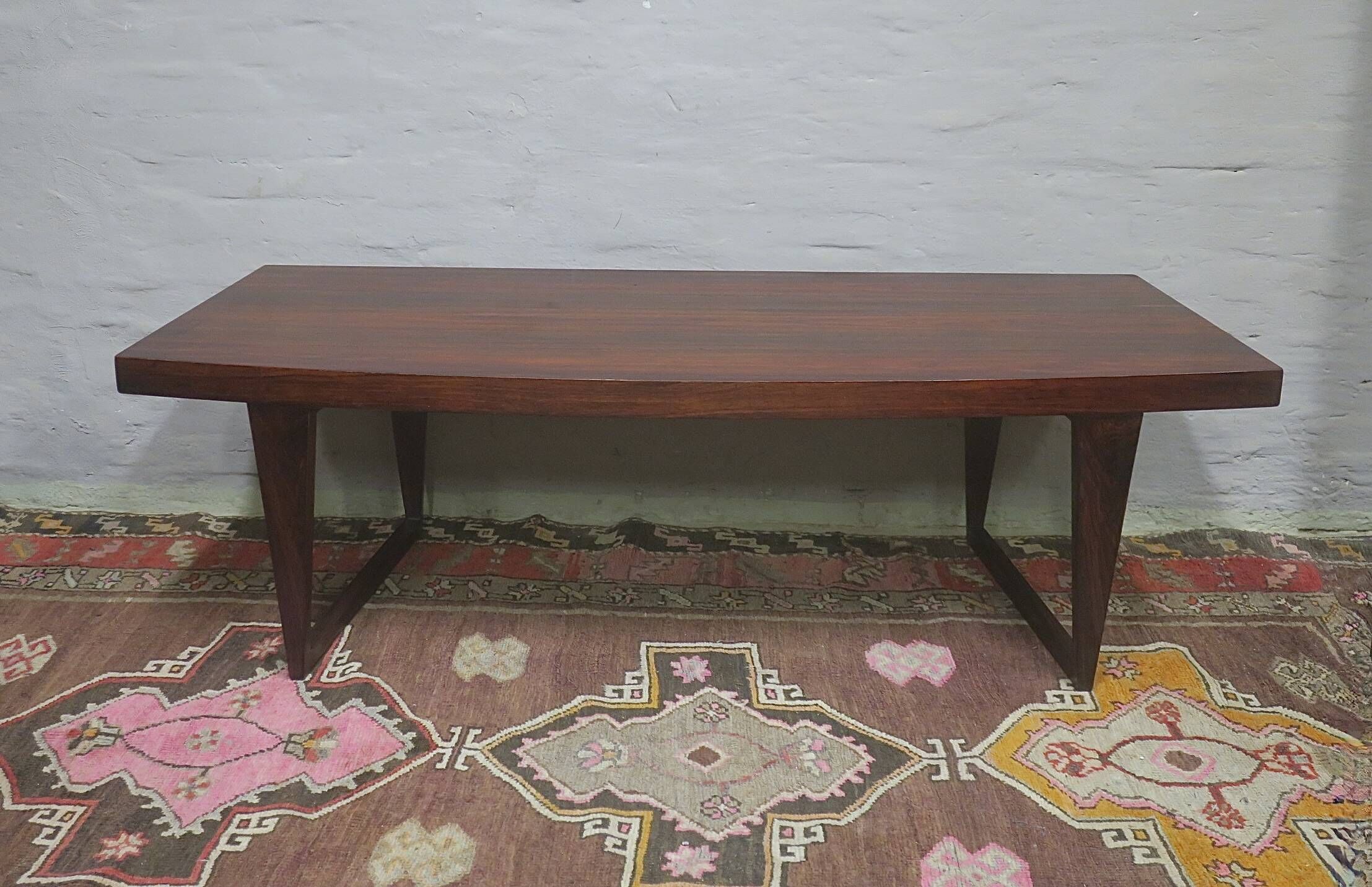 Table basse en palissandre danois avec un dessus courbé sur des pieds en traîneau par Leif Hansen, années 1960.