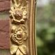 Old large oval wall mirror in golden resin