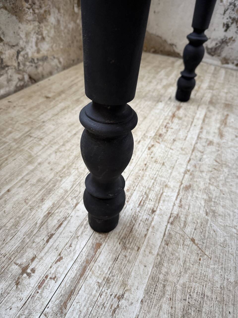 Oak farmhouse table with turned black legs.