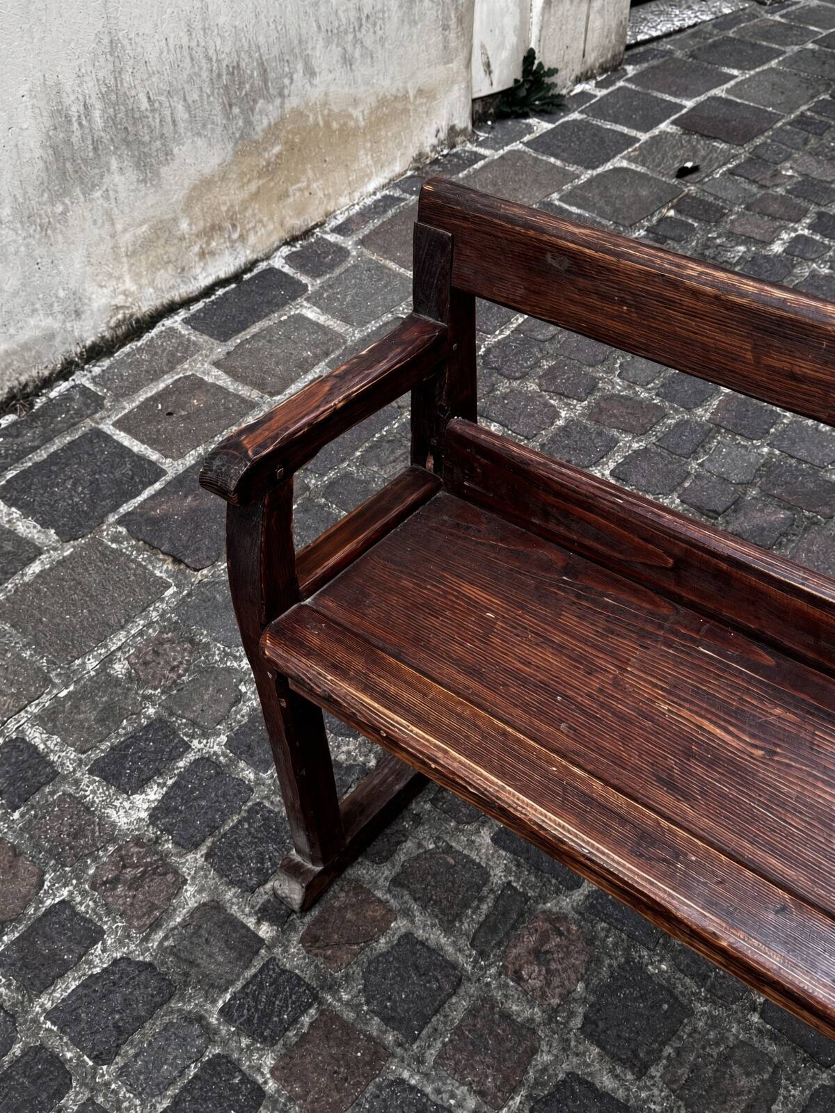 Old wooden bench with backrest and armrests