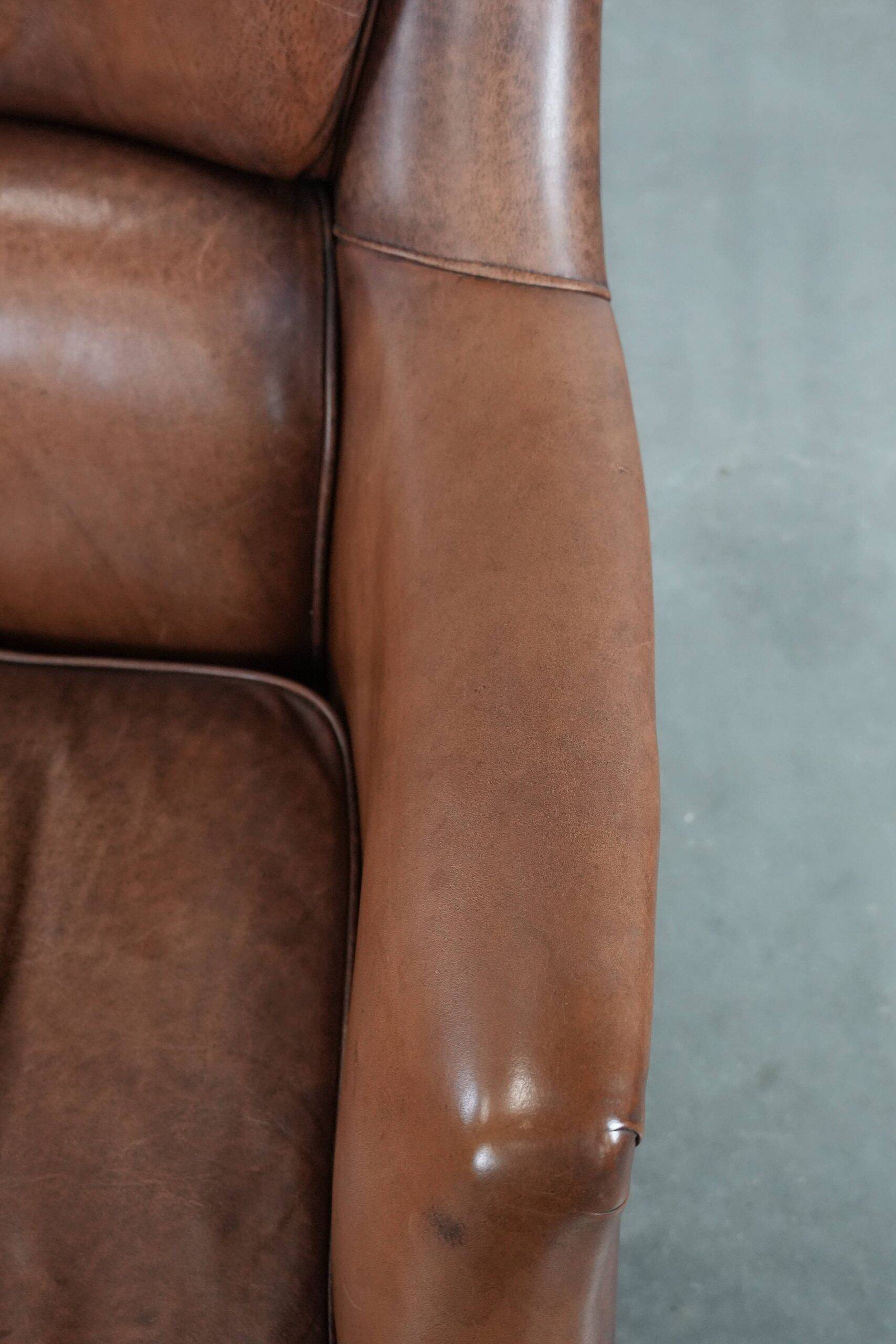 Cognac brown cow leather armchair with decorative nail finish