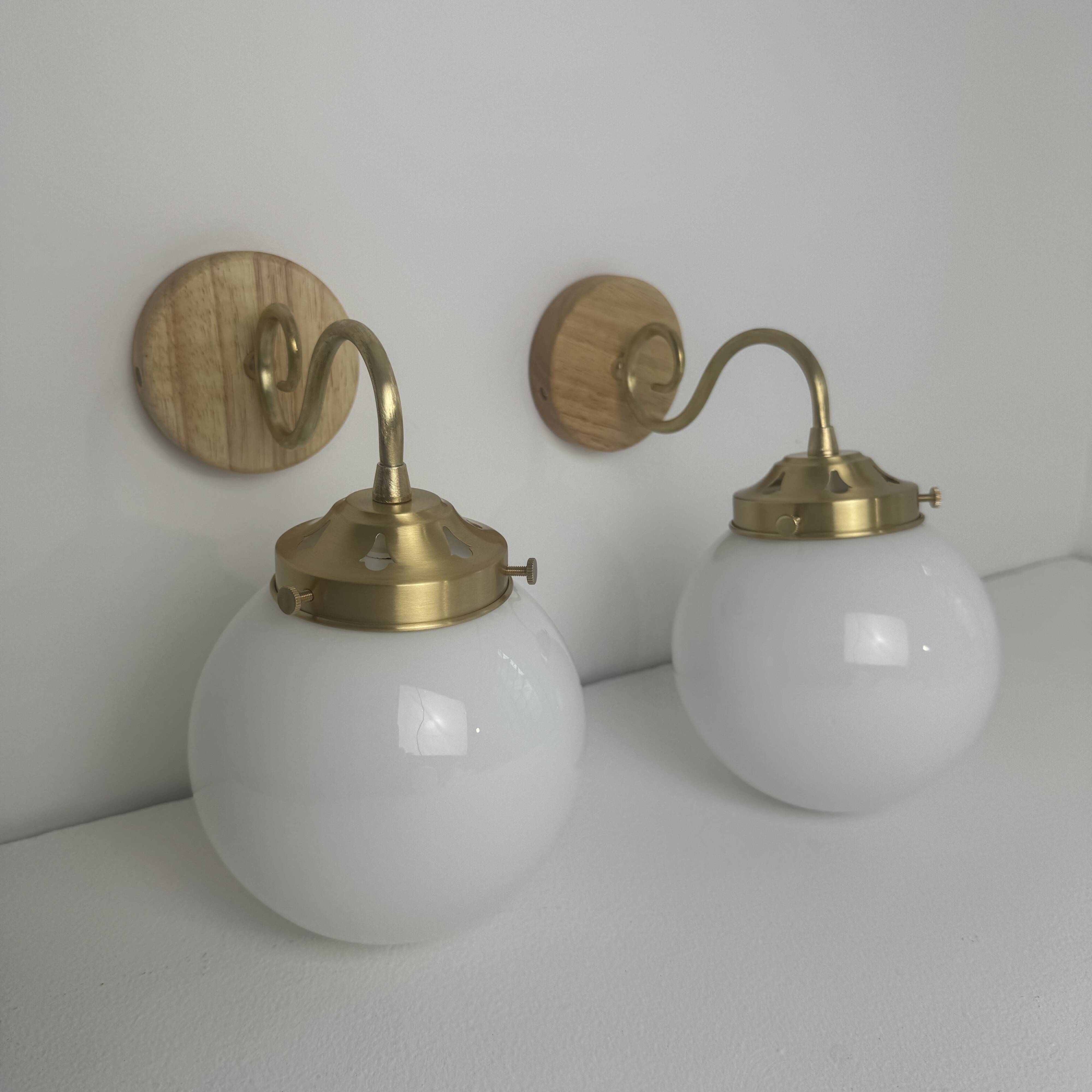 A pair of vintage opaline and brass wall lights