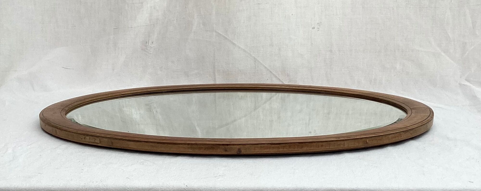 Oval beveled mirror surrounded by light wood dimension: height -74,5cm- width -38,5cm- prof-2cm-