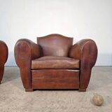 Important pair of Havana leather club armchairs, moustache models, mid-20th century.