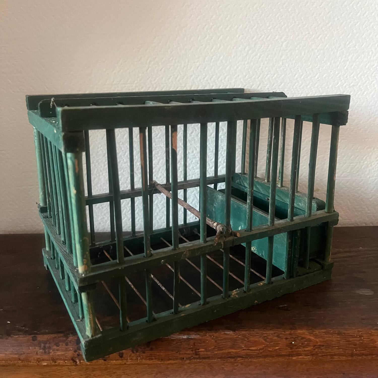 old bird cage made of wood and painted green