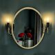 Oval wall mirror in gilded brass with double sconces – 1950s/60s