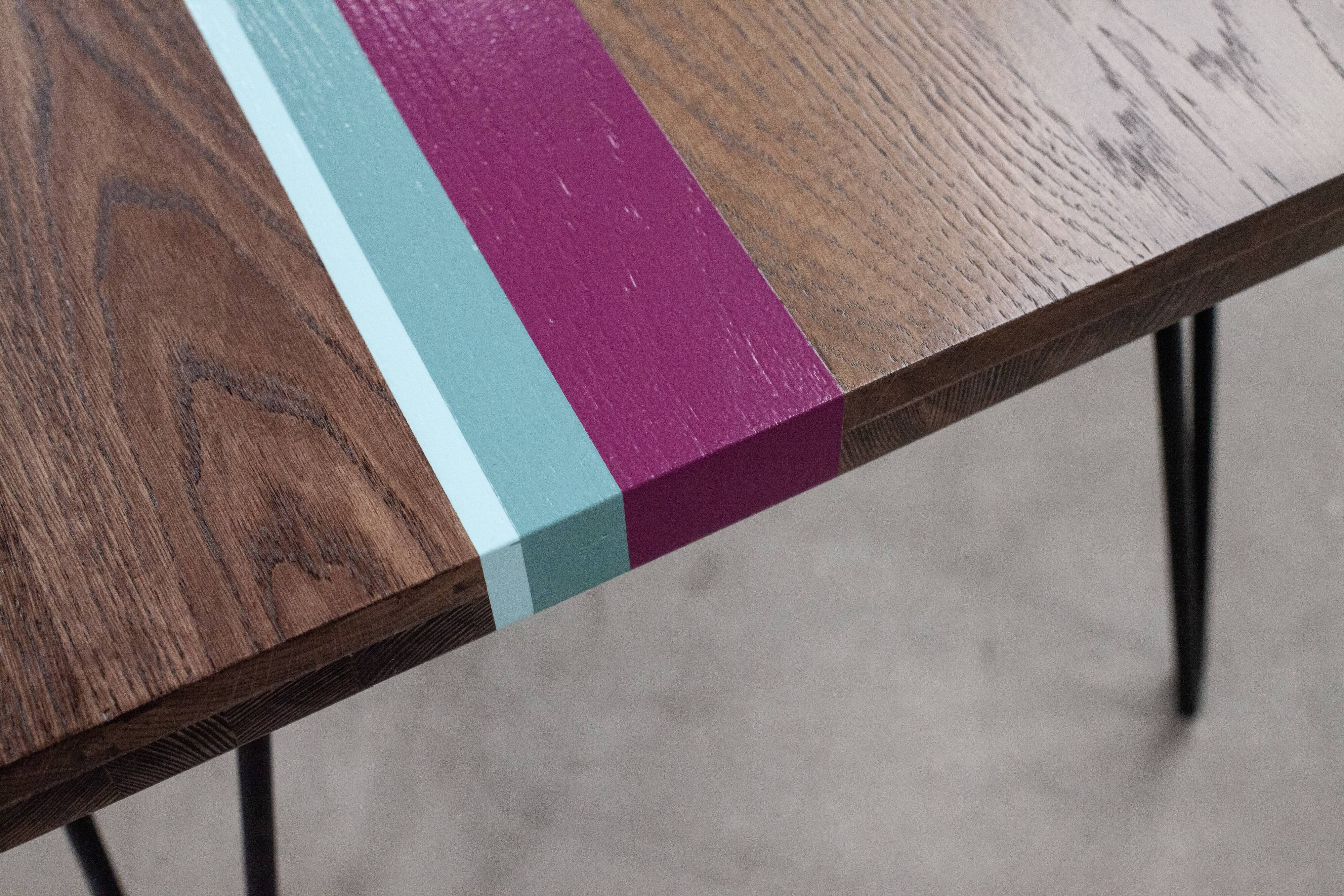 Solid oak coffee table with colored bands on pin legs