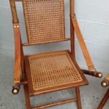 Pair of folding chairs in bamboo and caning, leather and brass