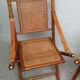 Pair of folding chairs in bamboo and caning, leather and brass
