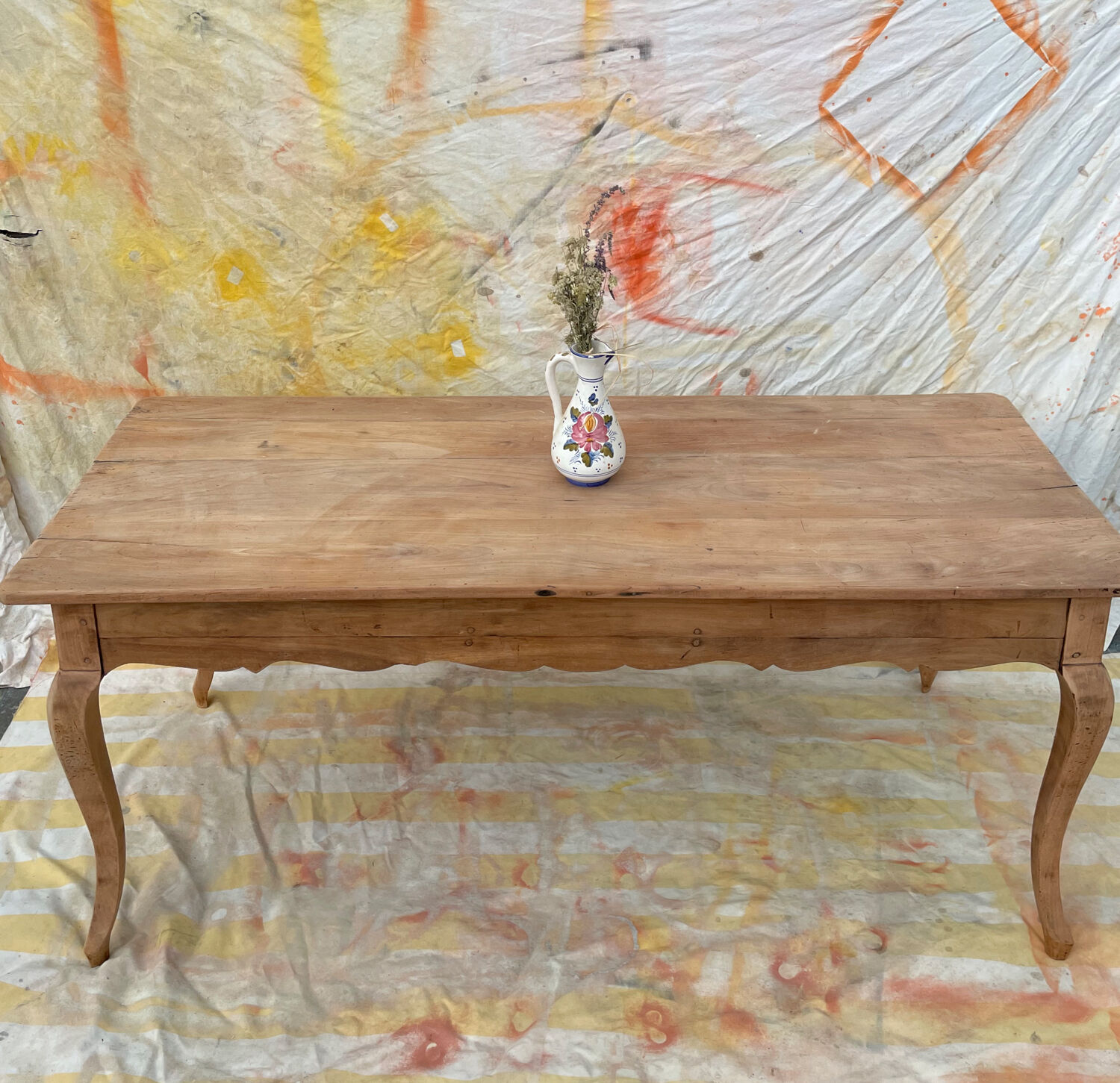 Curved farmhouse table in rustic wood, Provençal style.