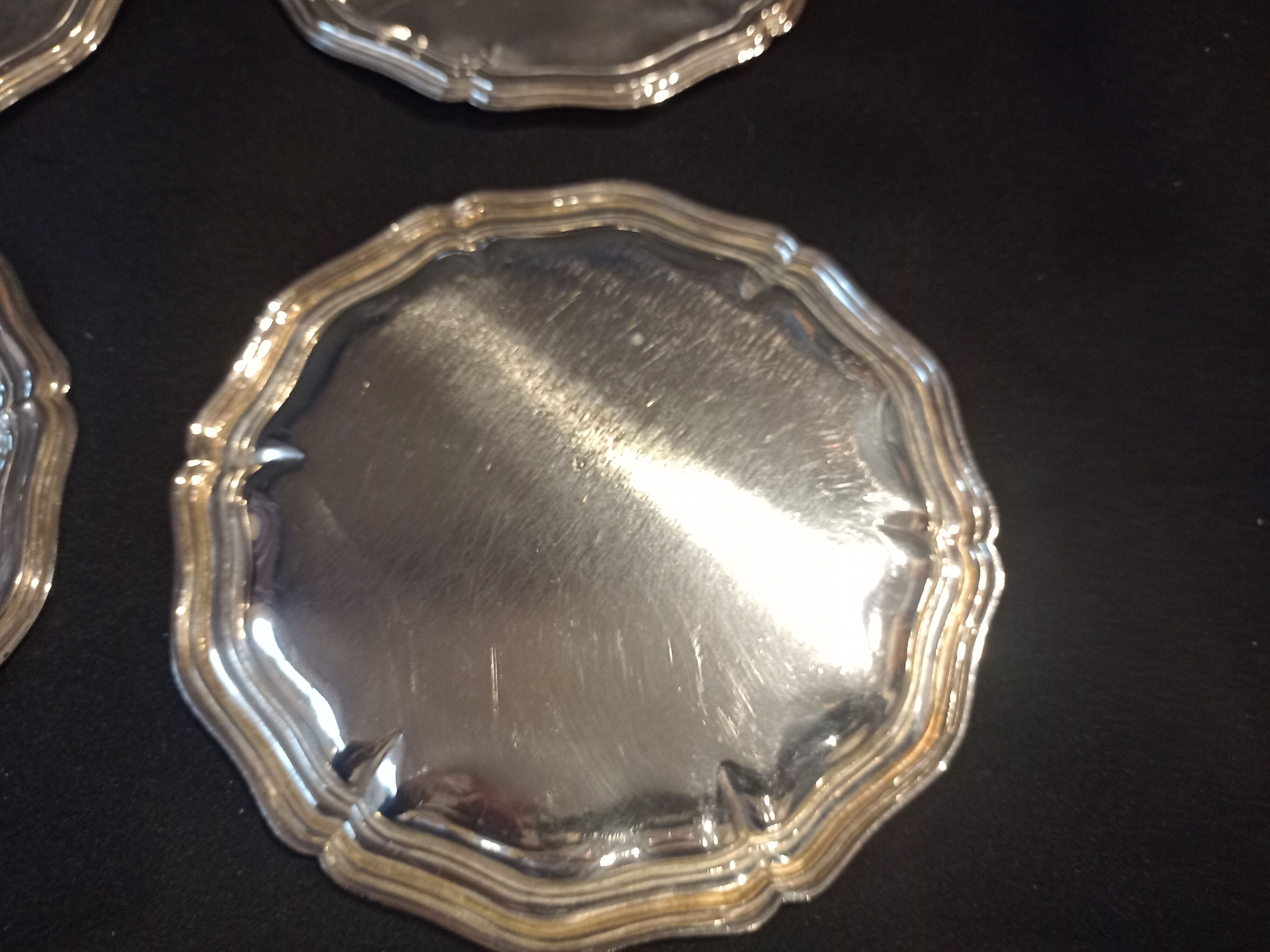 Four silver metal bottle bottoms