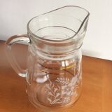 Old glass water pitcher with white flowers in relief with gold edging