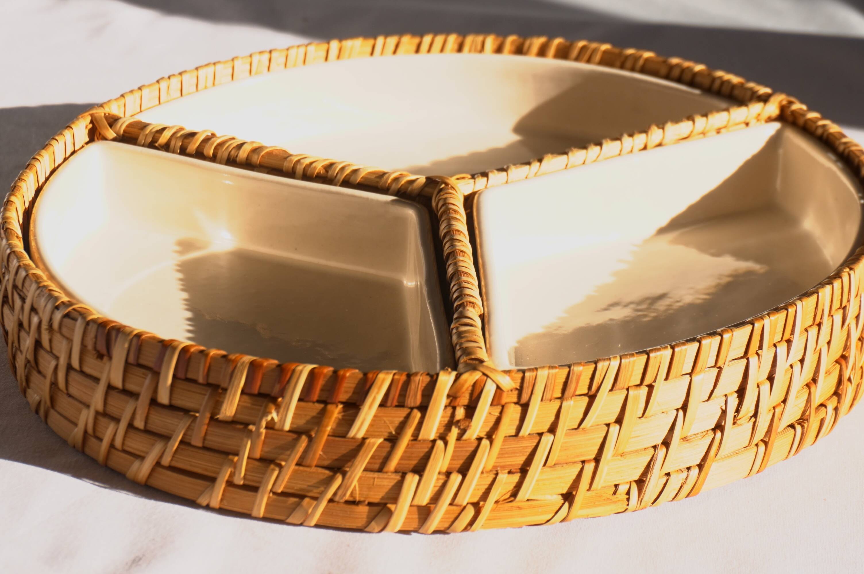 Compartment dish for appetizers, made of porcelain with a wicker support.