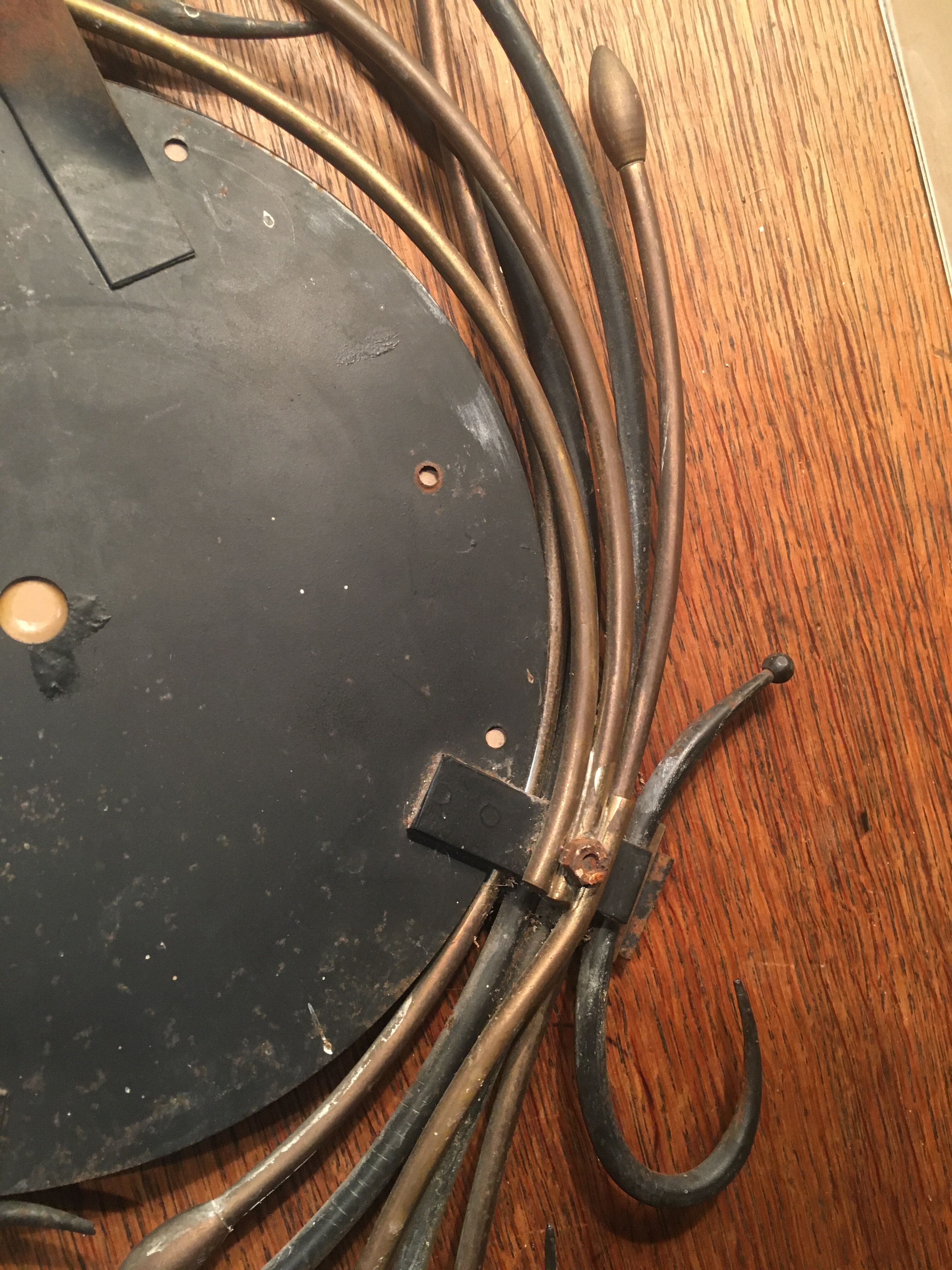 Round mirror surrounded by art deco style metal plants