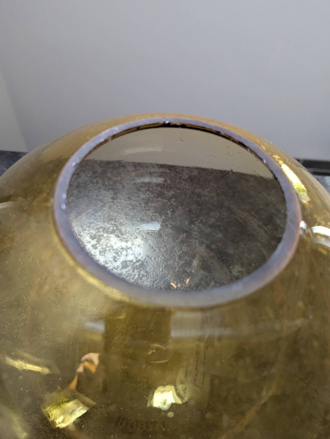 Old large and imposing thick glass globe with a bubbled amber colour, vintage.