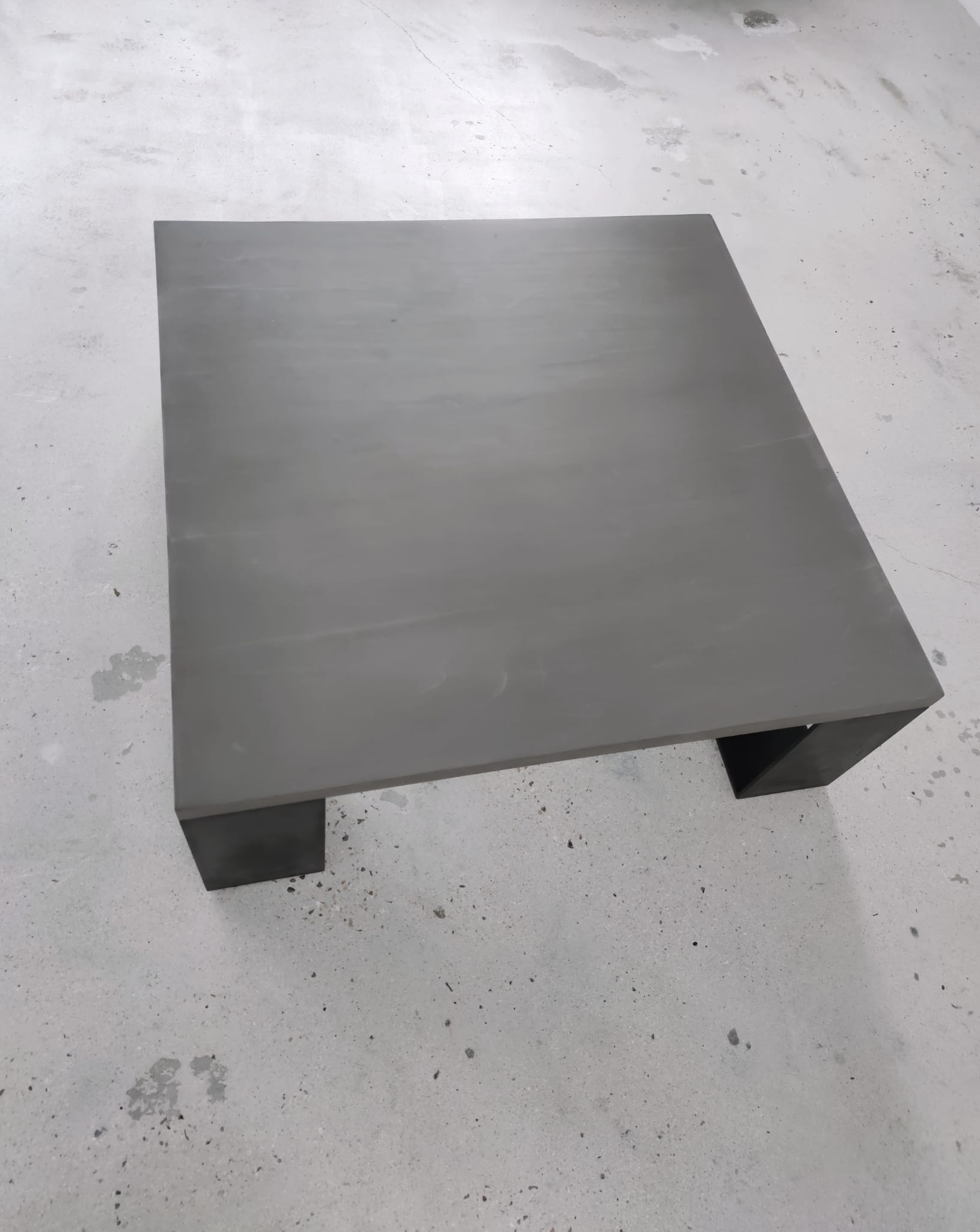 Table basse minimaliste en béton ciré et acier massif 1m20x1m20
