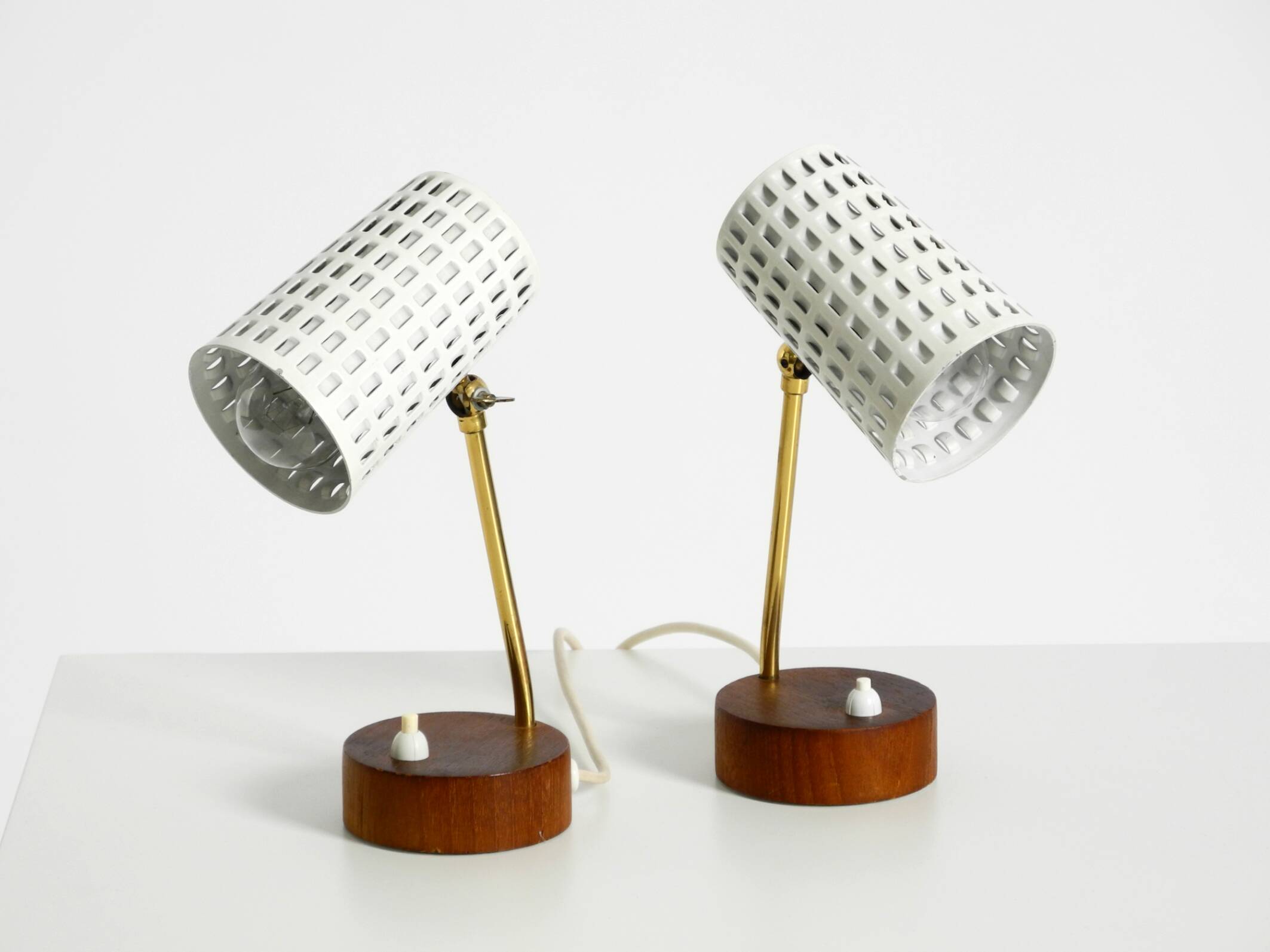 A pair of mid-century modern bedside lamps with perforated metal shades
