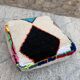Berber floor pouf: Handwoven Moroccan wool cushion.