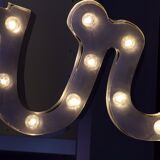 Enseigne lumineuse en lettrage aluminium formant le mot "bar"