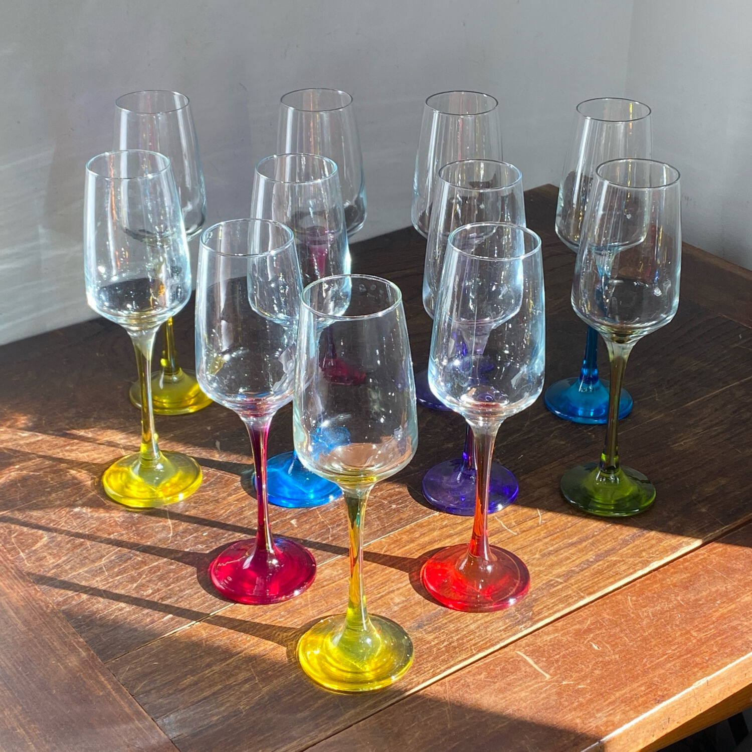 Champagne coupes in glass, multicoloured stems.