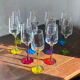 Champagne coupes in glass, multicoloured stems.