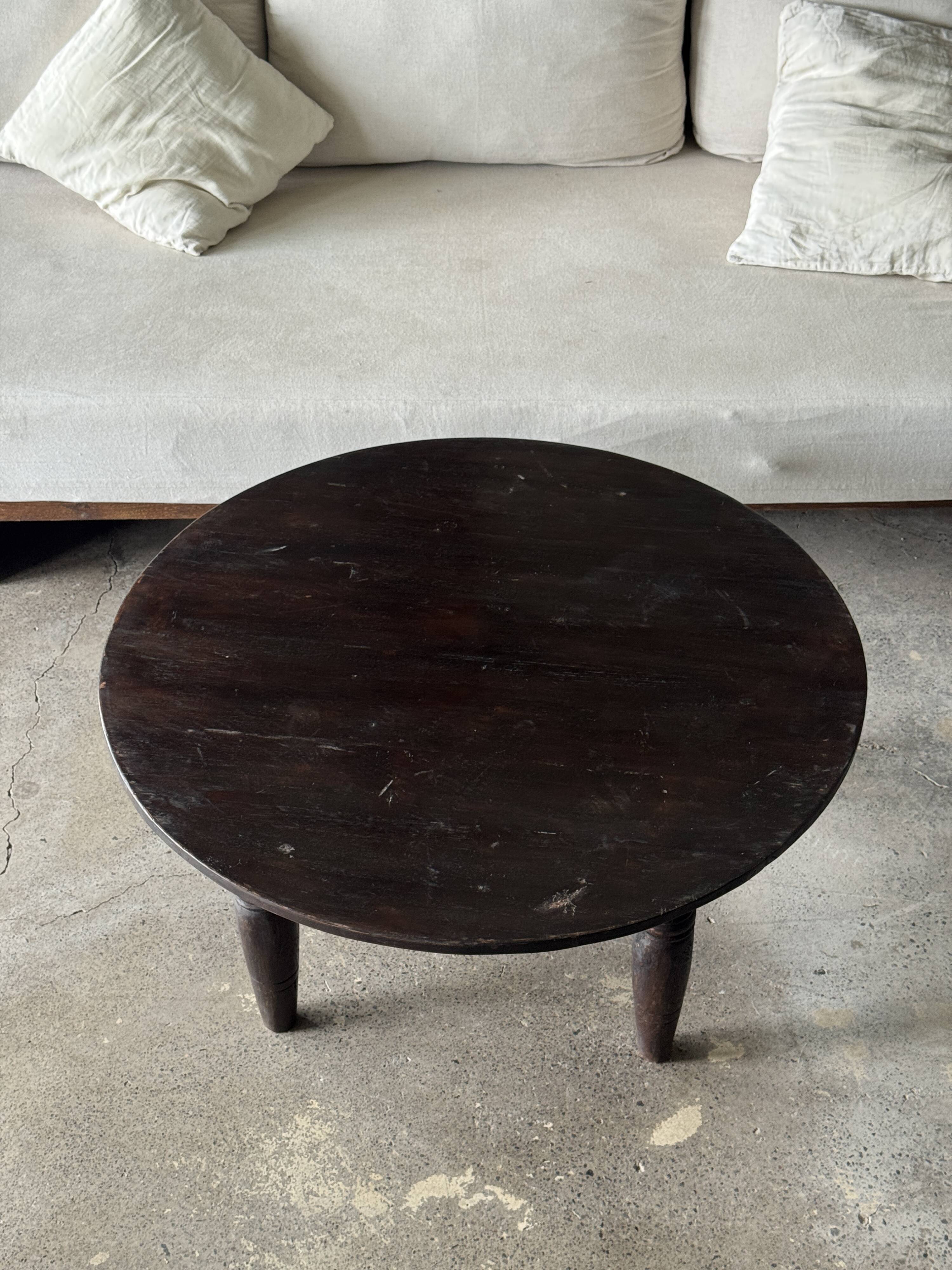 Antique round coffee table in Indonesian teak with turned legs.