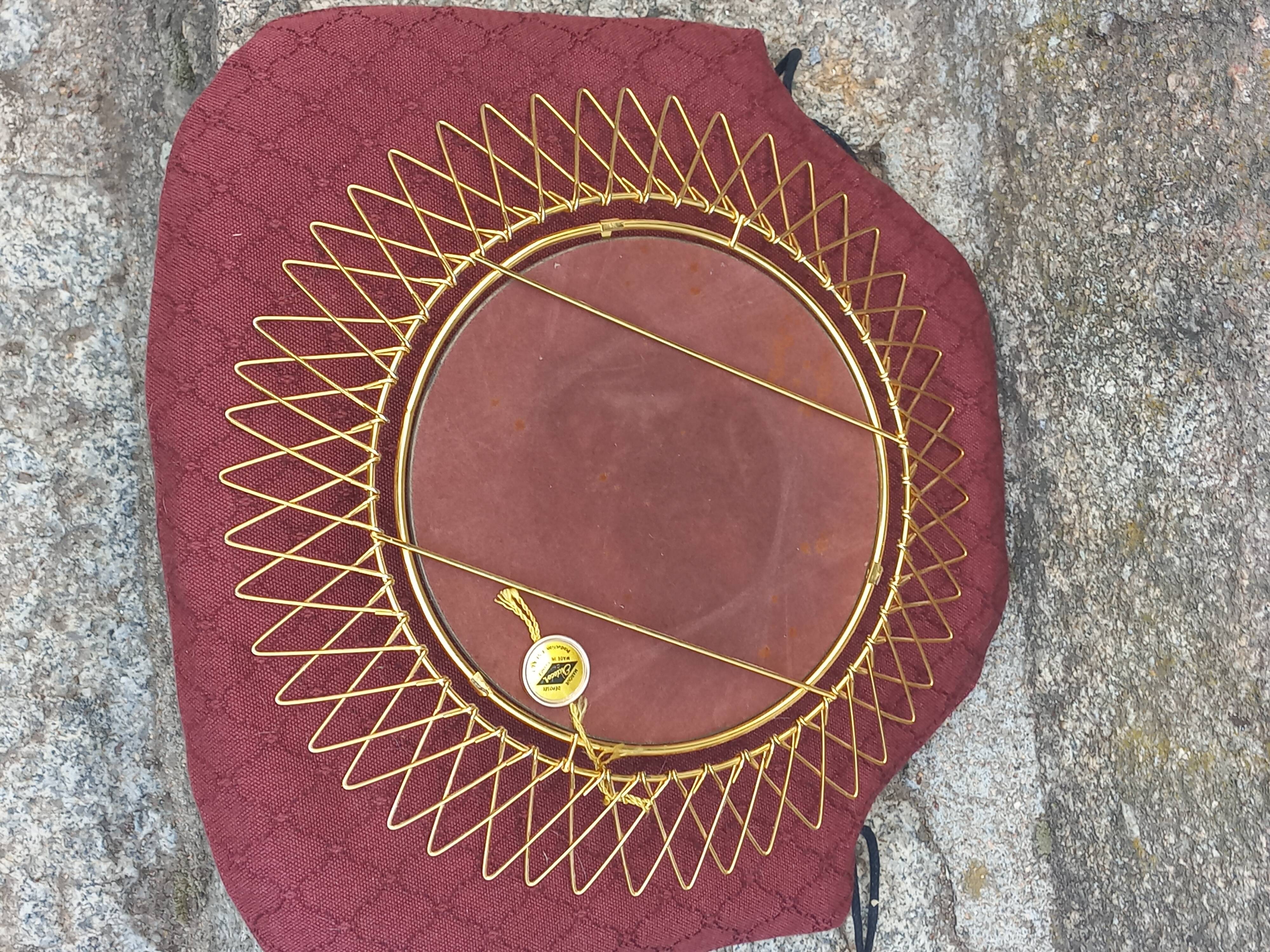 Vintage 1950s sun mirror in gold metal.