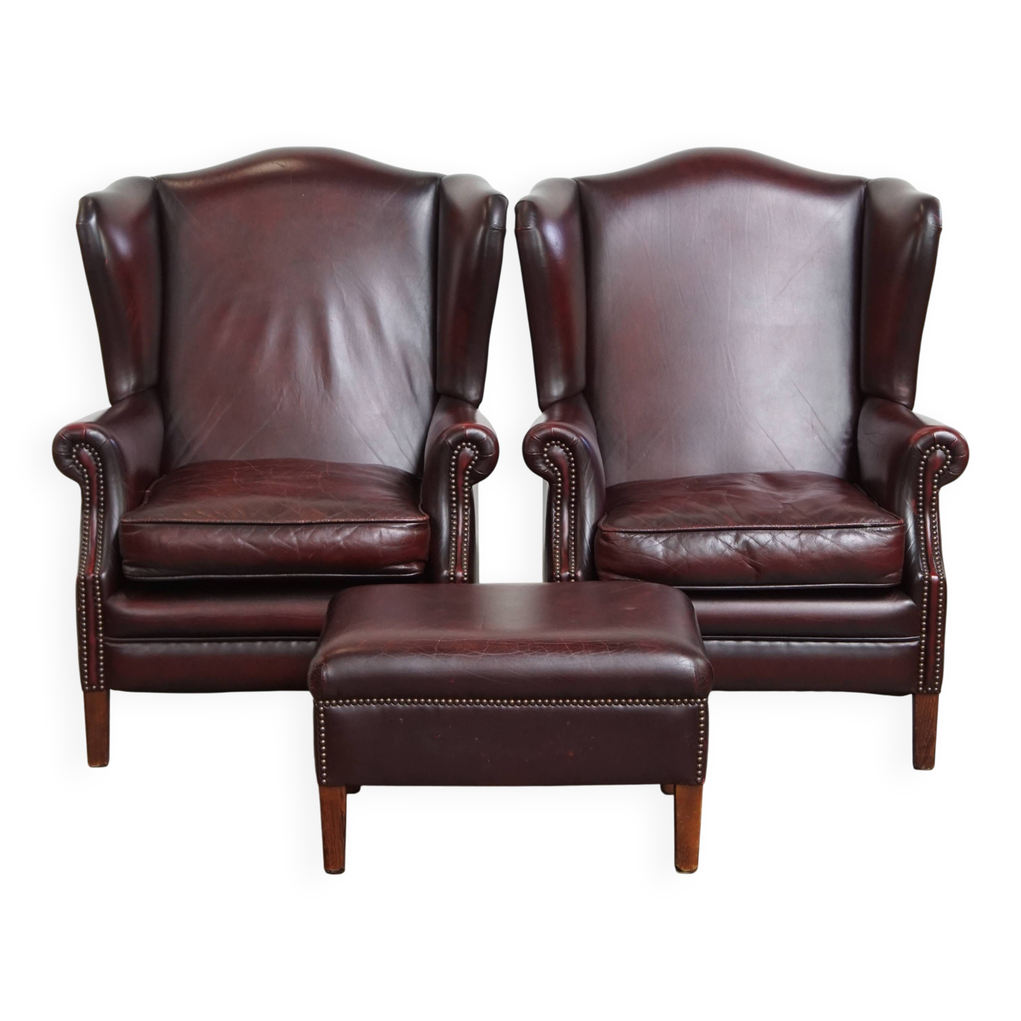 Ensemble de 2 fauteuils à oreilles en cuir de vachette + pouf de style anglais