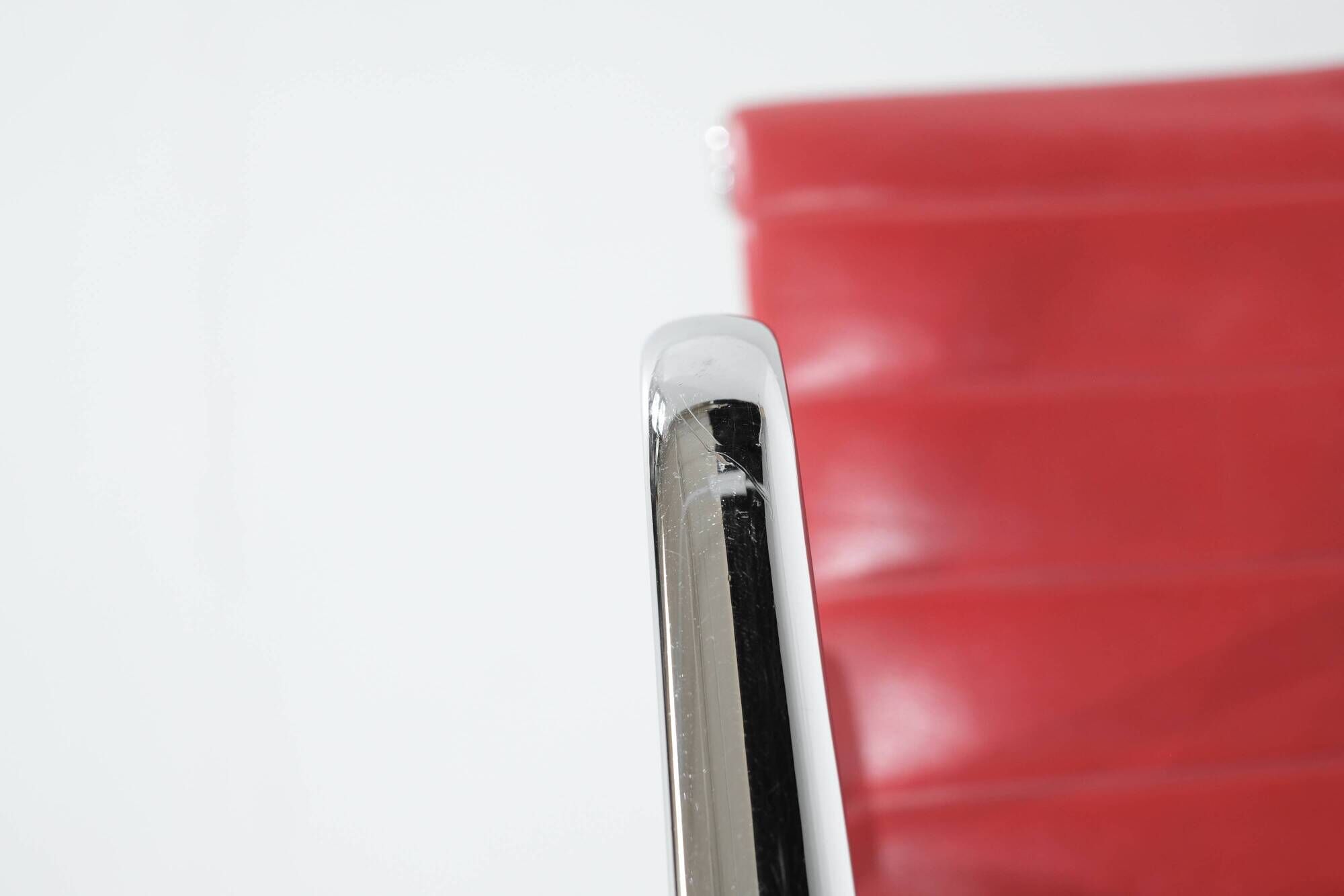 "EA 108" armchair in red leather, designed by Charles and Ray Eames for Vitra,