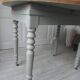 Walnut table with raised flaps, base on verdigris casters.