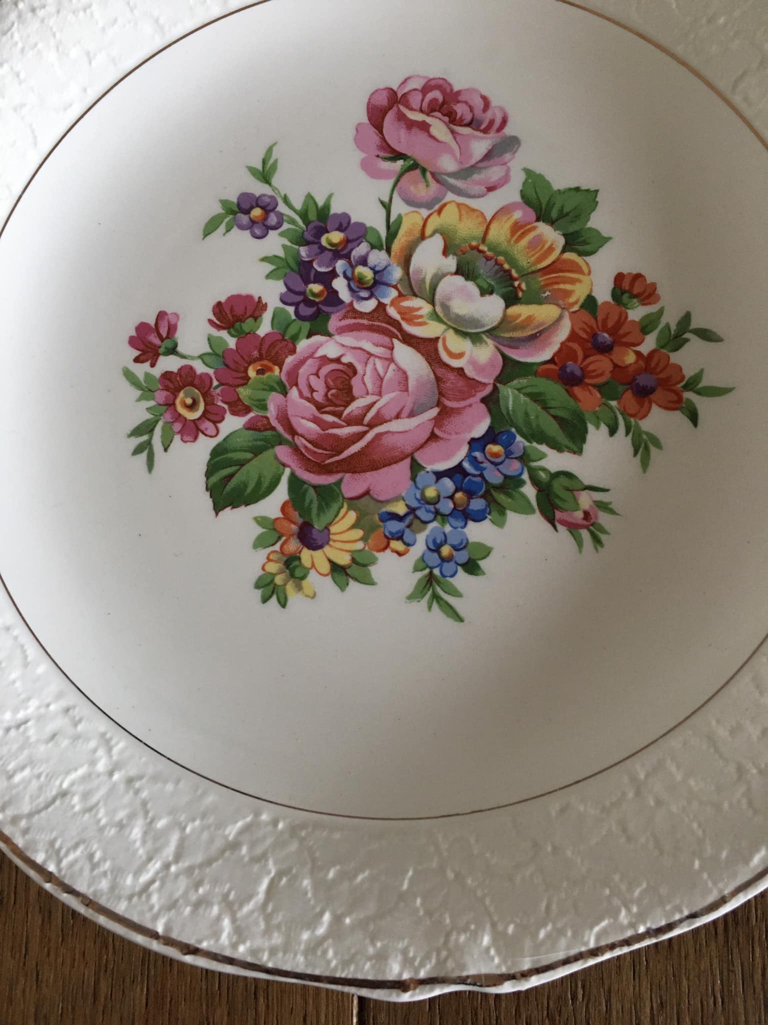 4 mismatched flat plates with floral patterns. Porcelain. Stamped