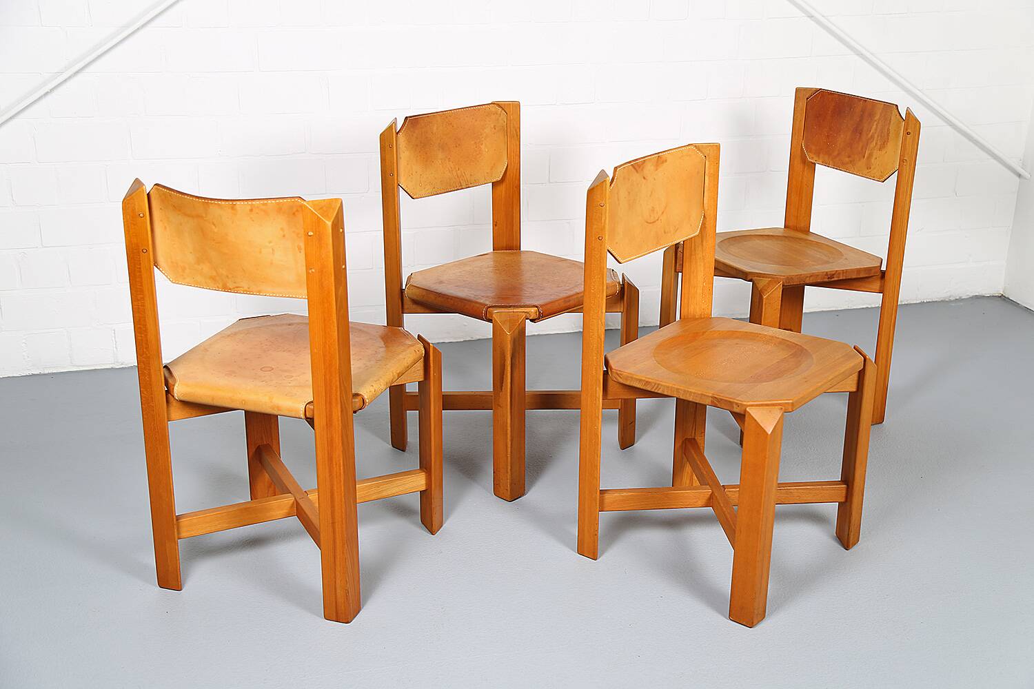 Set of 4 dining chairs in elm wood and cognac leather.