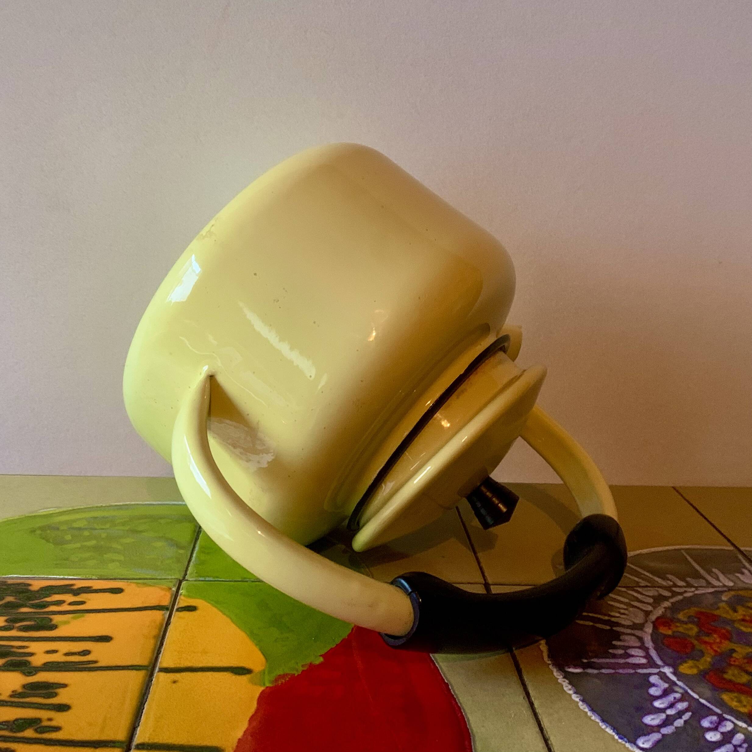 Old kettle in yellow enamelled sheet metal and Bakelite
