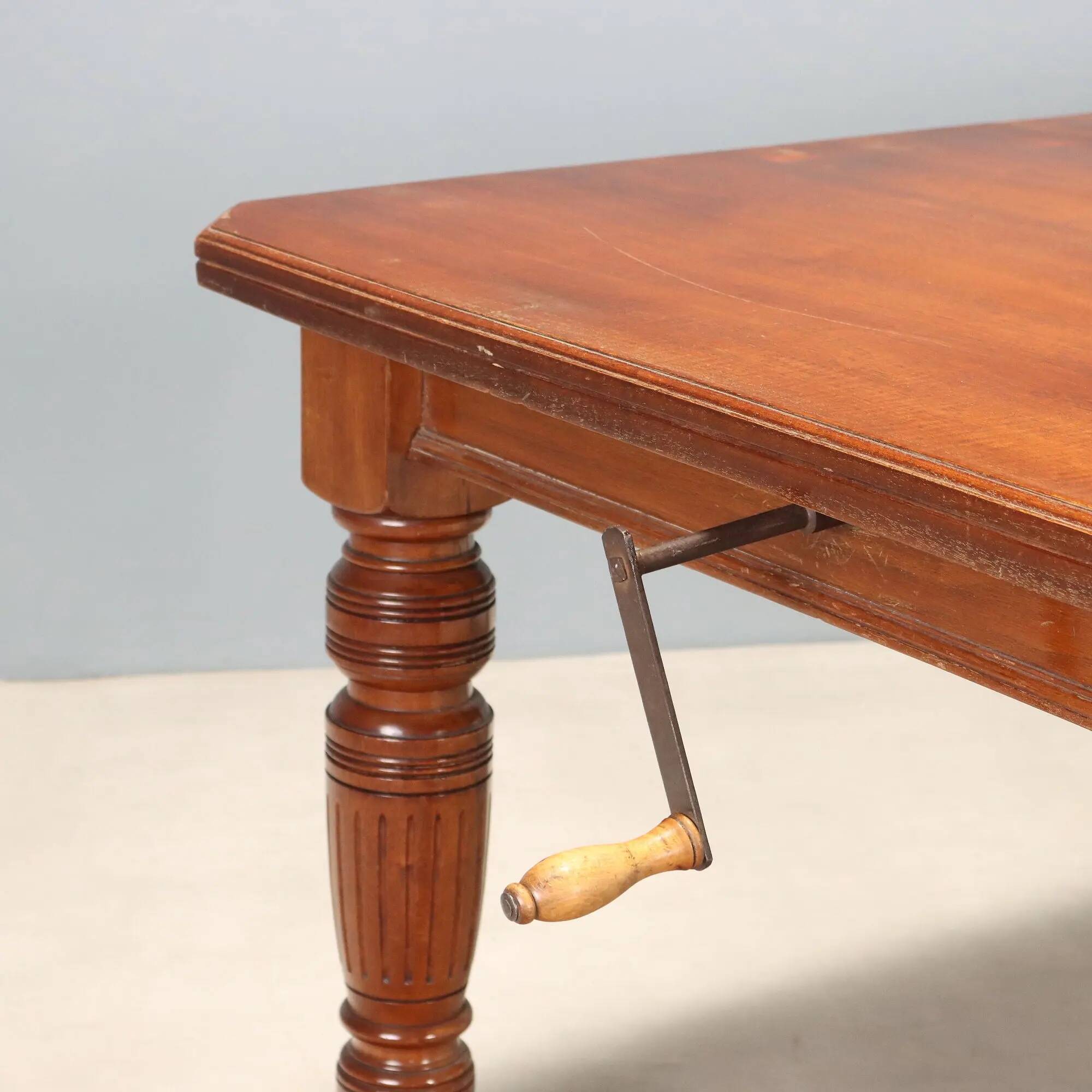 Antique extendable mahogany table with a crank mechanism, United Kingdom.
