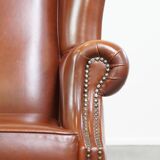 Correct, comfortable, luxurious English-style wingback armchair made of cognac-colored cow leather