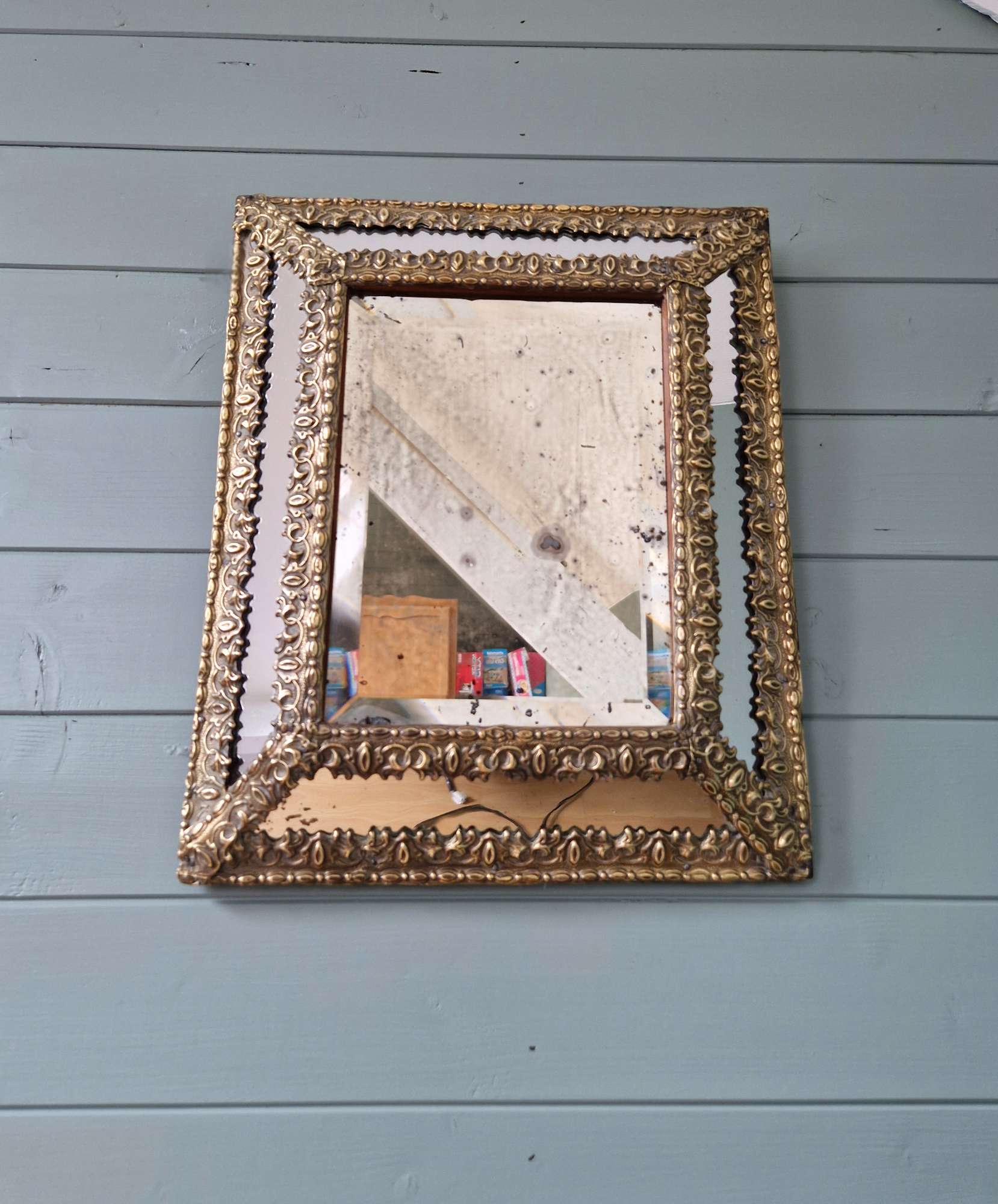Mirror with repoussé brass frame, mercury glass, 19th century.