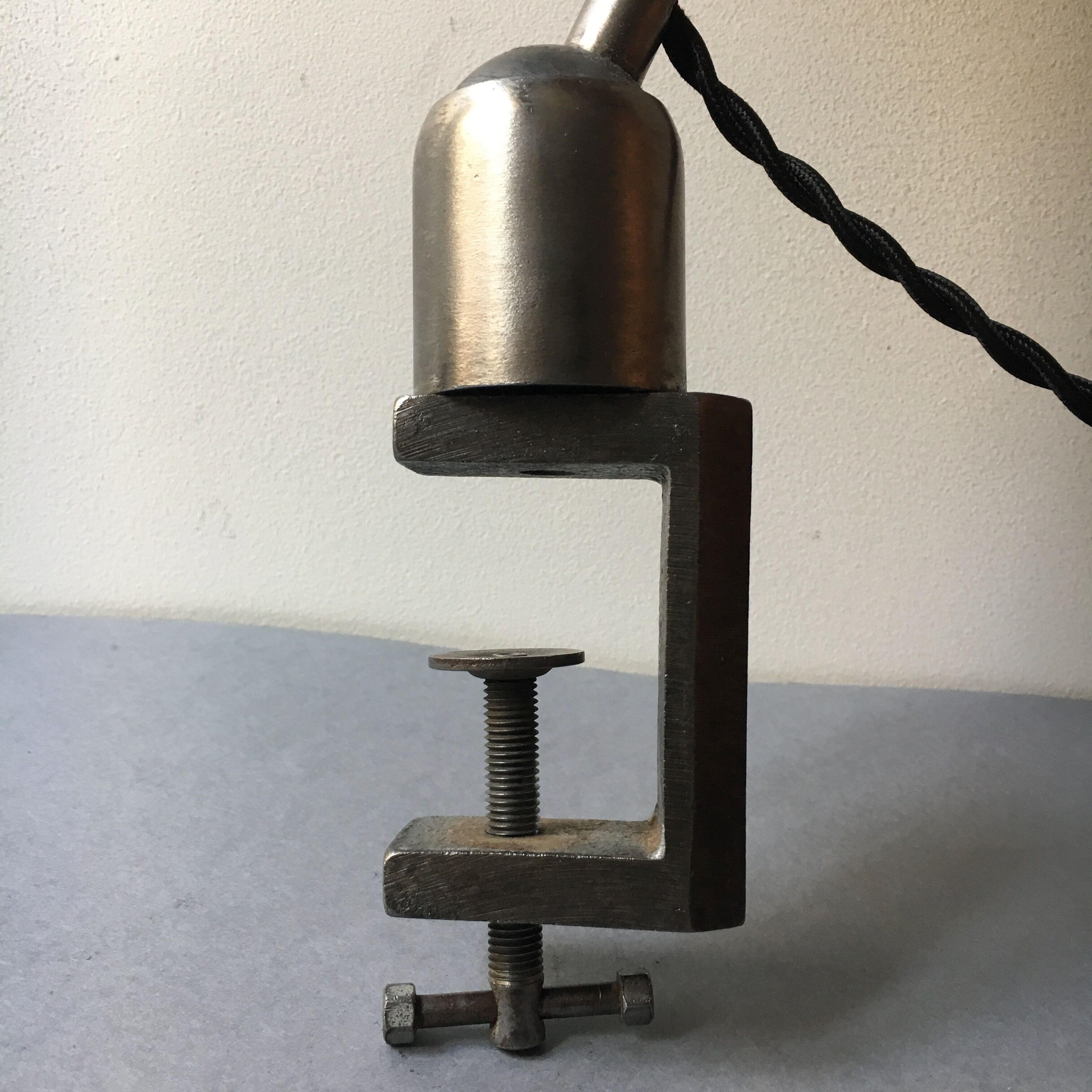 Old industrial lamp has vise 'mazda '.