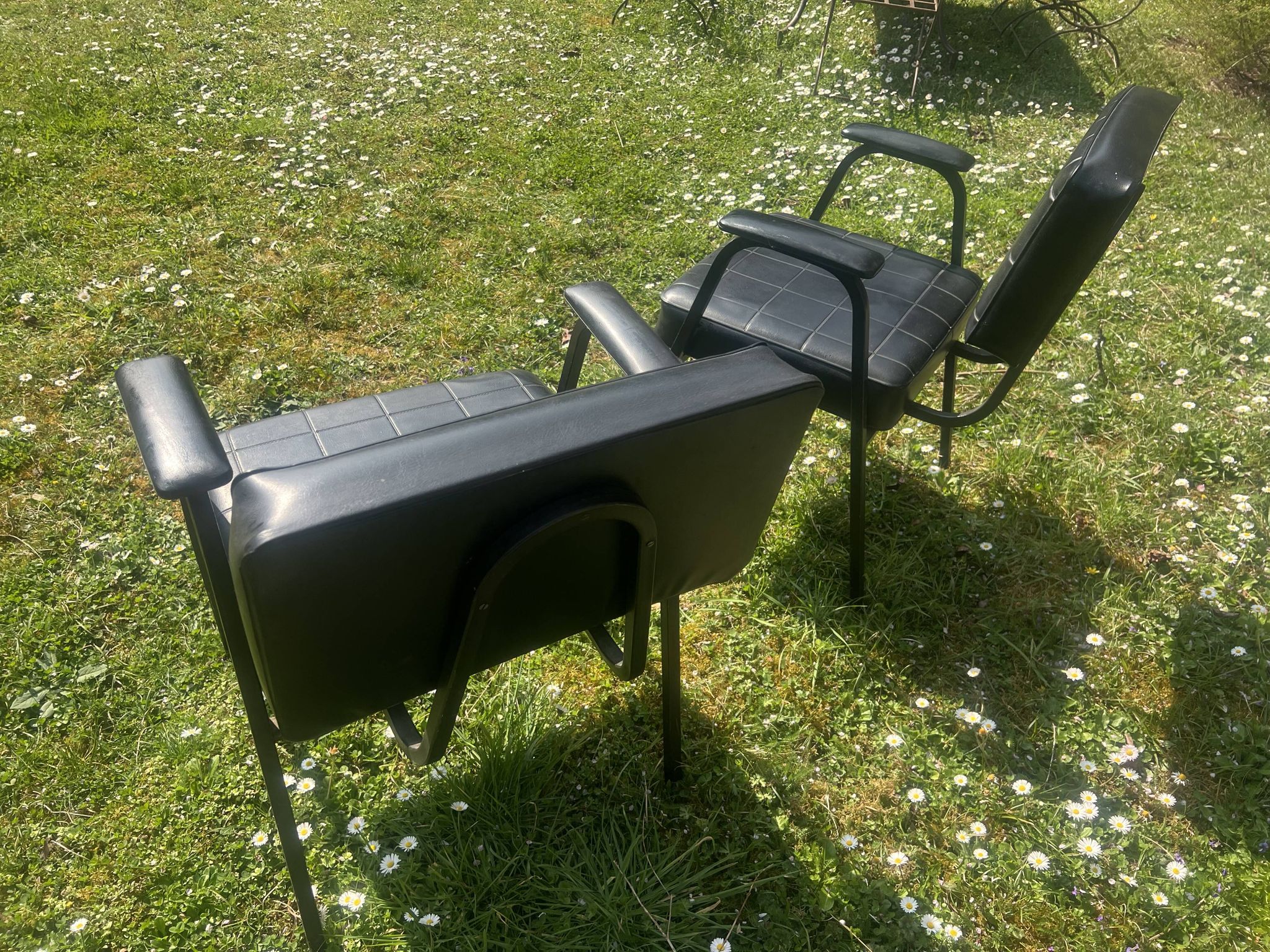 Pair of vintage industrial armchairs in black imitation leather and metal legs