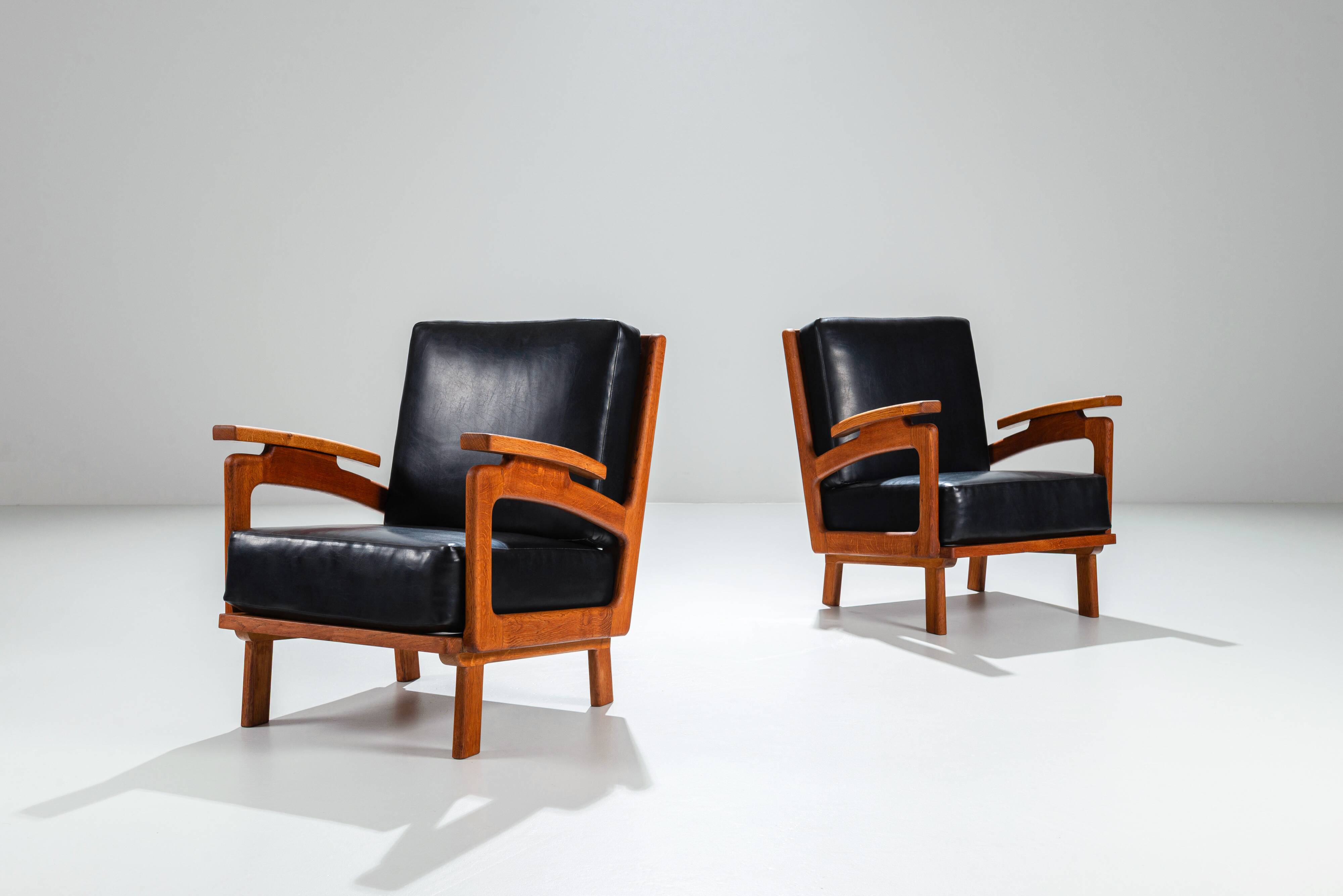 Pair of Belgian lounge chairs in solid oak with leather cushions
