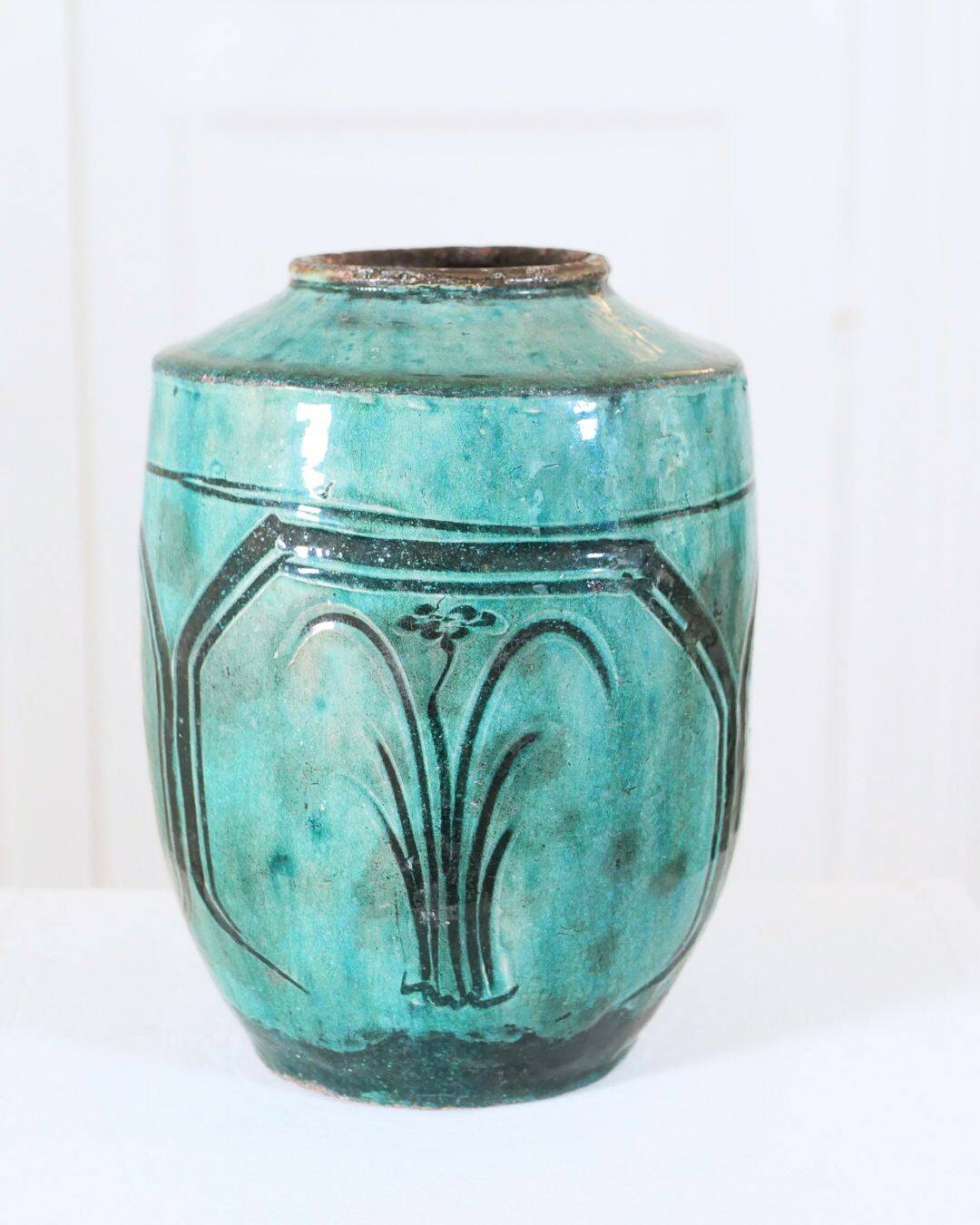 Chinese glazed earthenware vase with bird and flower decoration on a green background