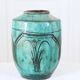 Chinese glazed earthenware vase with bird and flower decoration on a green background