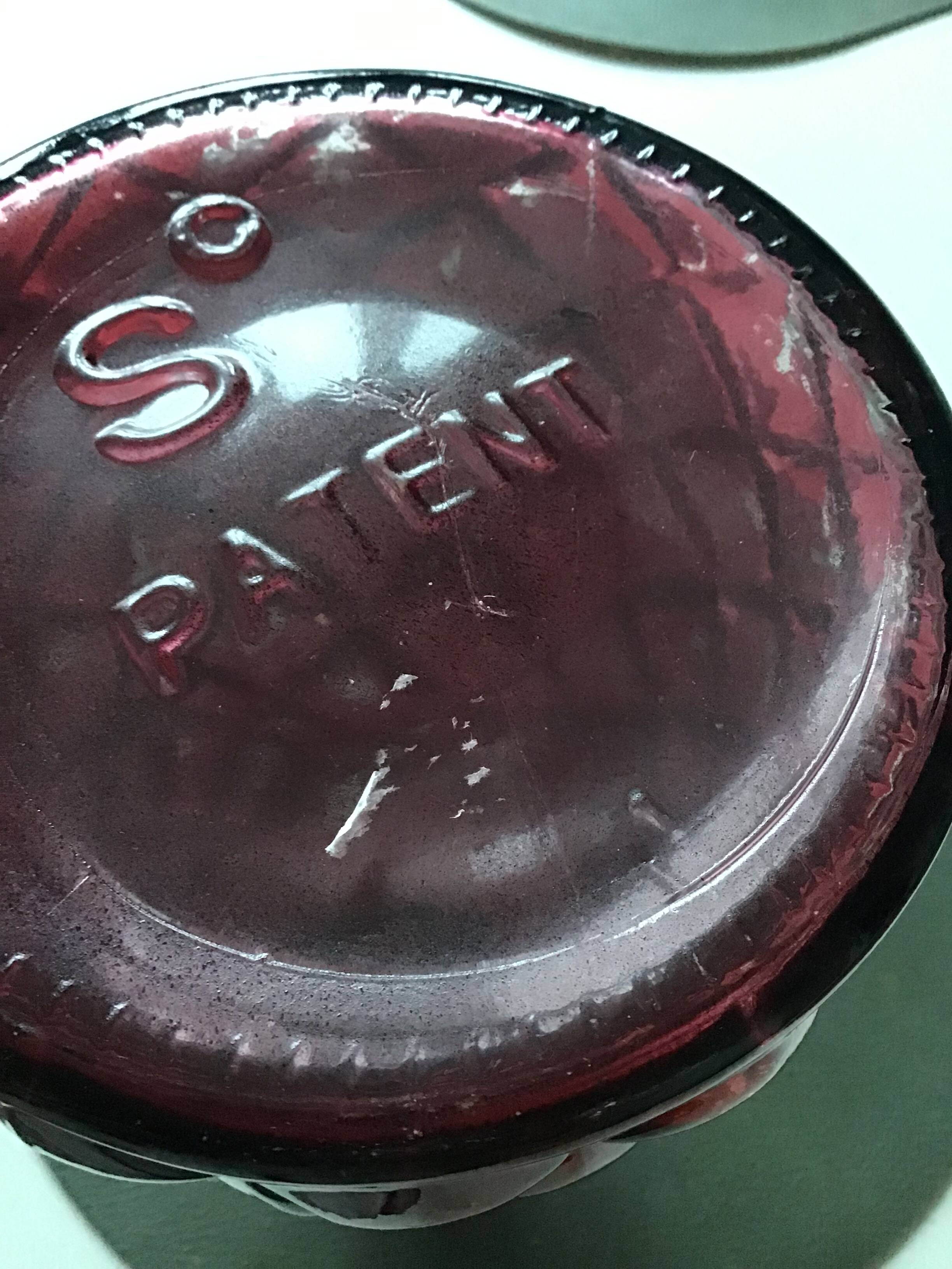 2 red molded glass bottles or jars