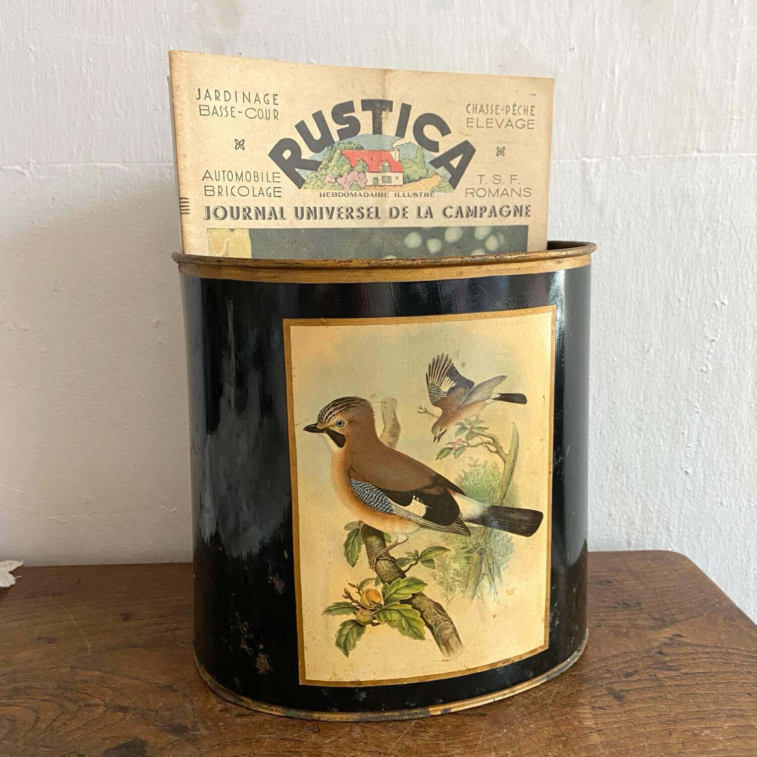Metal wastebasket with bird decoration