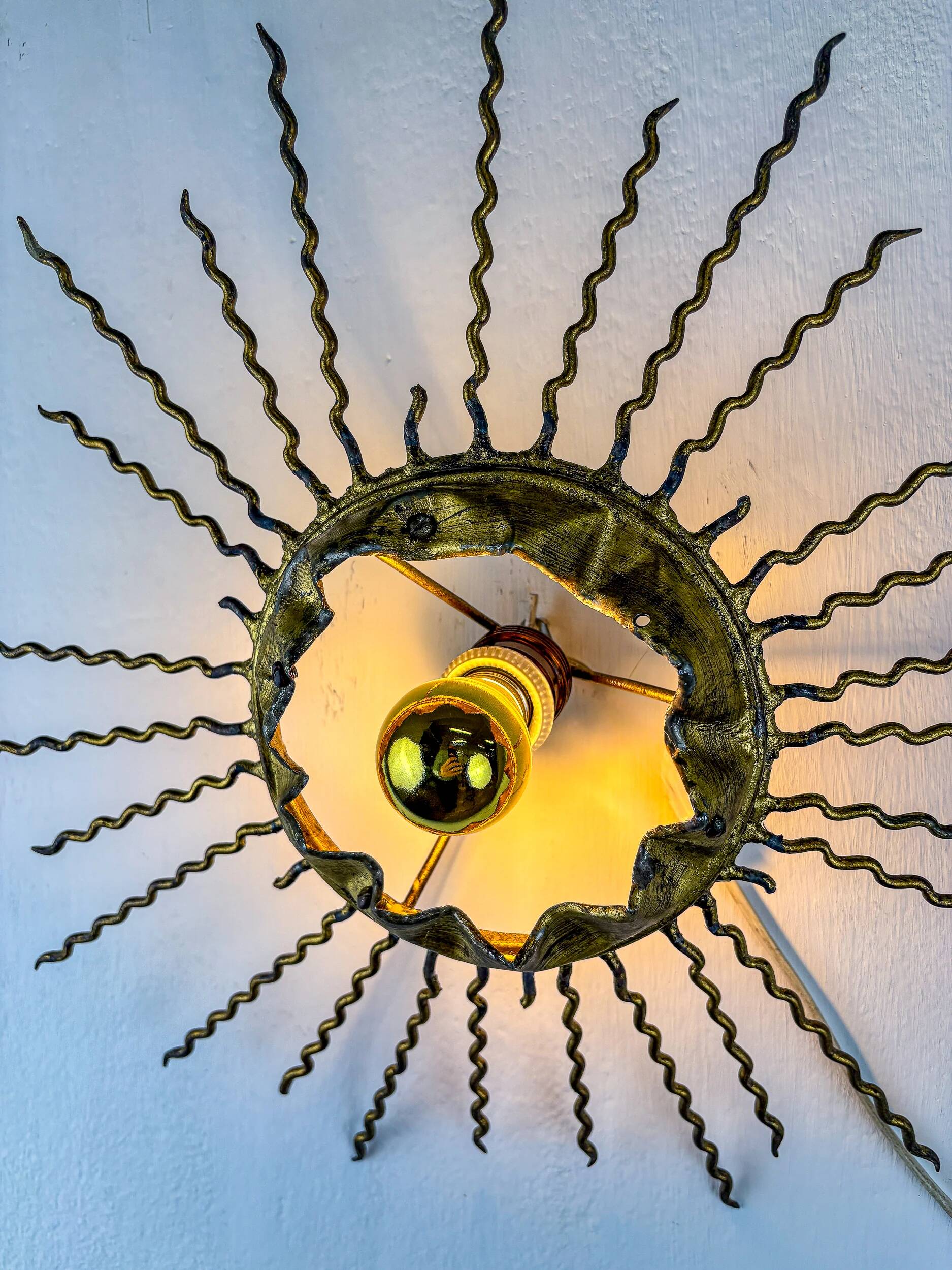 Spanish sunburst ceiling light – gilt iron rays & exposed bulb, 1960s