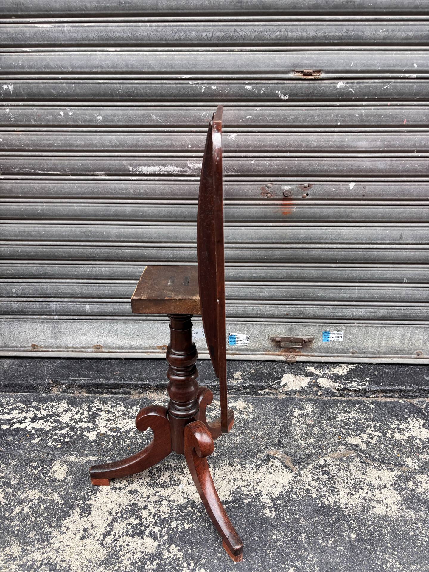 19th-century solid mahogany table with a tilting top and brass mechanism.