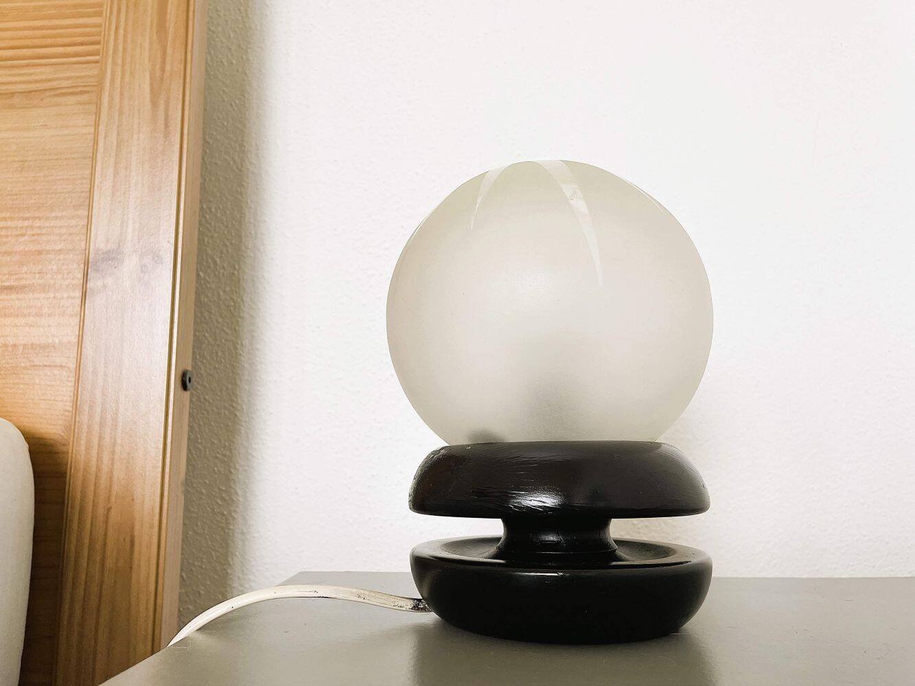 Small black wooden table lamp with frosted glass globe
