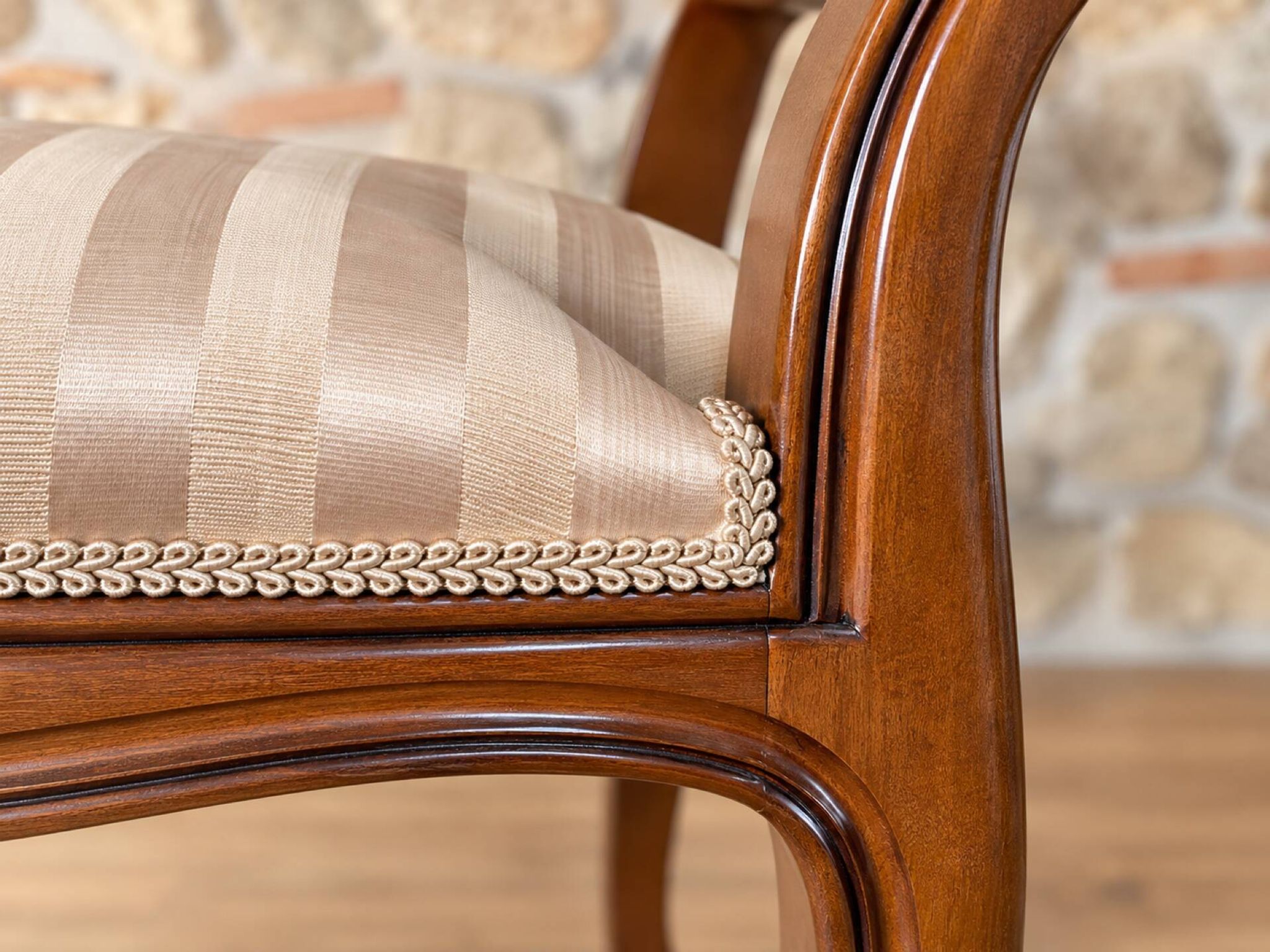 Two-seater bench in carved wood, with curved armrests.
