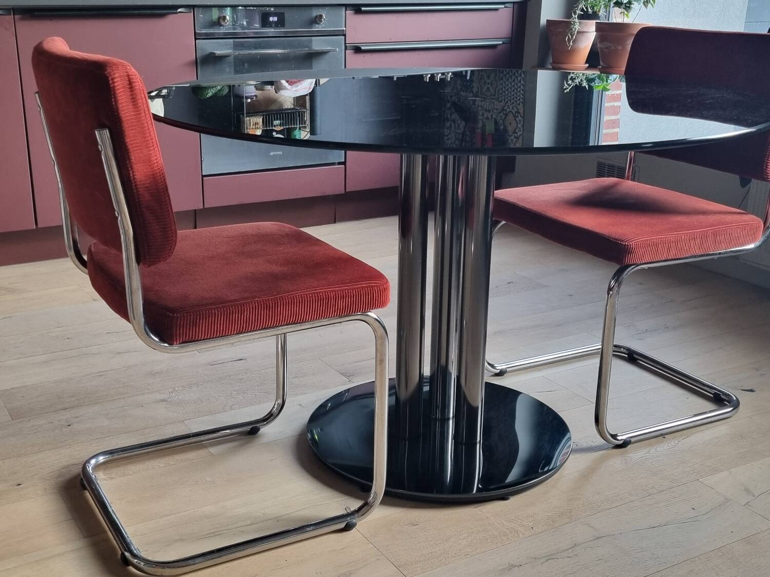 Round black smoked glass dining table + 2 terracotta chairs