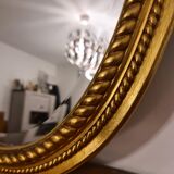 Beveled oval mirror in gilded wood 78×58cm
