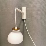 Milky white Holmegaard wall lamp with glass shade and a brass detail on top. Wooden wall bracket